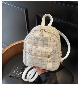 Dettaglio della trama in tweed bianco e delle cerniere dorate sul mini zaino di lusso da donna