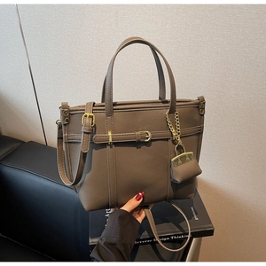 Detail of lychee textured leather tote bag in dark khaki with gold hardware