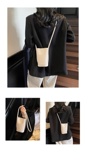 Detailed view of the lychee texture and cylindrical shape of this beige bucket bag