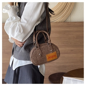 Brown tweed bowling bag with Jeans patch shown on a model for a casual daily commute look