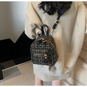 Dettaglio di un mini zaino in tweed con finiture dorate indossato sulla schiena