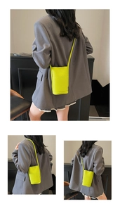 Detail showing neon green lychee texture leather phone bag with slim shoulder strap