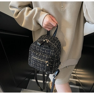 Dettaglio mini zaino in tweed con texture bianco e nero e chiusure lampo in metallo dorato