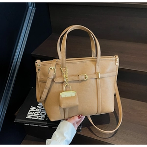 Detailed close-up of khaki litchi grain leather tote bag with adjustable strap and gold buckle