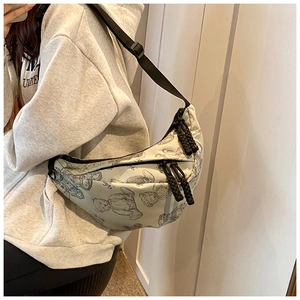 Detailansicht der cremefarbenen Mondsichel-Tasche mit Bärenprints und Nylonriemen