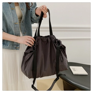 Detalle del bolso hobo de nailon impermeable en gris oscuro con cierre de cordón ajustable