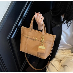 Close-up of caramel lychee grain leather tote with mini coin purse and gold chain