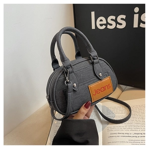 Detail of grey denim texture bowling bag featuring brown Jeans leather patch and handles