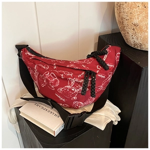 Detailansicht einer burgunderroten Tasche mit Bärenprint und breitem Nylongurt im Display