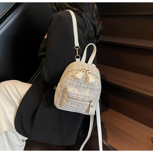 Dettaglio mini zaino in tweed crema elegante con hardware dorato e manico superiore