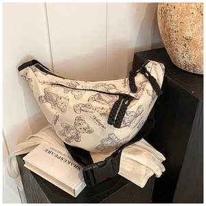 Detailansicht der cremefarbenen Segeltuchtasche mit Bärendruck und schwarzem Gurt