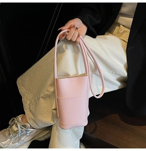 Detailed view of pink pebble grain leather phone bag with minimalist vertical structure