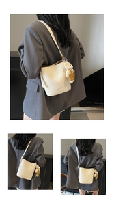 Detail view of lychee pattern bucket bag in white with cute brown bear charm