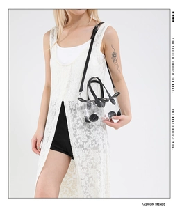 Mini-Tasche aus transparentem PVC mit schwarzem Lederbesatz, präsentiert vom Model