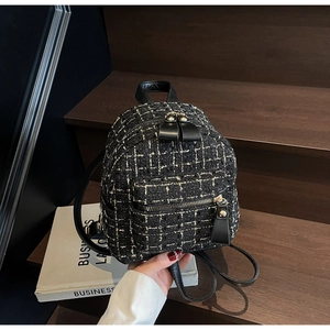 Dettaglio mini zaino in tweed bianco e nero con finiture in metallo dorato lucido