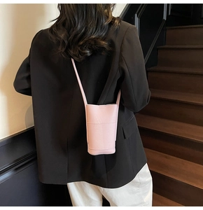 Pink lychee texture PU leather phone bag worn by a model in a casual outfit