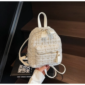 Dettaglio mini zaino in tweed bianco con finiture dorate e inserti in pelle