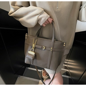 Detail view of coffee brown lychee textured tote bag with golden hardware and coin purse