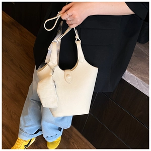 Detailansicht der cremefarbenen Bucket-Bag aus Leder mit Lychee-Narbung und Münzfach