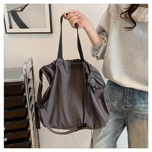 Vista detallada del bolso hobo de nailon gris oscuro con cierre de cordón y hebilla