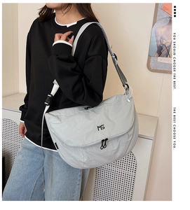 Close-up of light gray nylon tote bag featuring MS logo and adjustable strap buckles