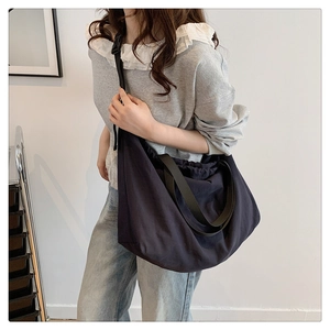 Detalle de bolso hobo grande de nailon ligero con correa de hombro ancha ajustable en gris oscuro