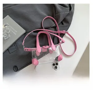 Detailansicht der rosa transparenten Mini-Tasche im Größenvergleich mit einem Handy