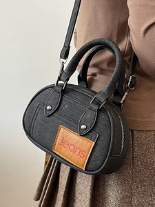 Retro black leather bowling bag with jeans logo shown on a model in autumn style