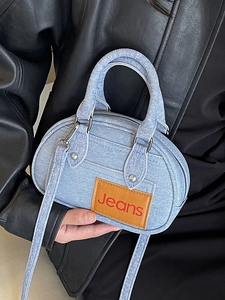 Light blue denim handbag with brown leather patch and adjustable crossbody strap