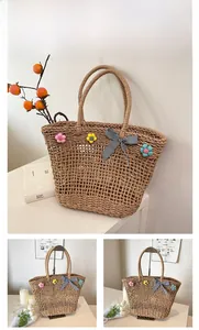 Detail of handmade straw tote bag featuring 3D floral accents and gingham bow knot