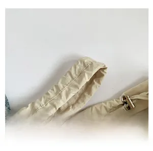 Detail of pleated shoulder strap with metal buckle and double stitching on nylon bag