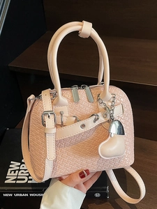 Pink woven texture shell handbag with round handles and adjustable strap in hand