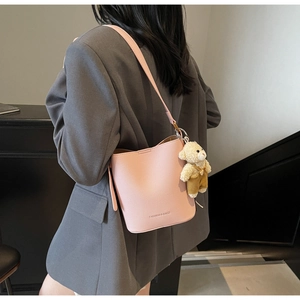 Pink lychee grain leather bucket bag with fashion lettering and cute teddy bear charm