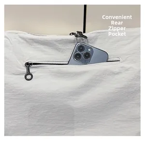 Macro shot of the back zipper pocket on white nylon tote bag holding a large smartphone