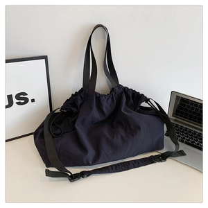 Detalle del bolso hobo de nailon con correa de hebilla ajustable y cierre de cordón