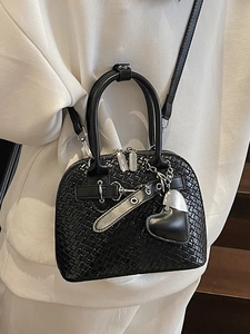 Fashionable black shell handbag with woven texture and heart charm shown on model