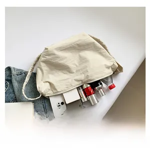Top view showing large capacity of cream shoulder bag with mobile phone and cosmetics