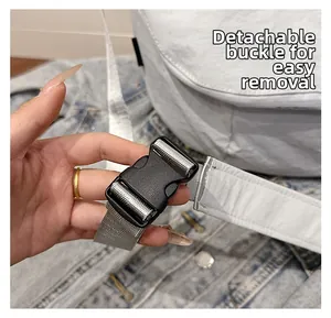 Detail of the white travel tote showing durable grey strap and detachable black plastic buckle