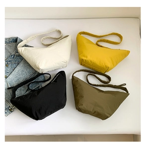Detailed overhead view of minimalist nylon dumpling bags in four assorted colors
