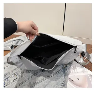 Interior view of grey nylon tote bag showing zipper pocket and open compartments