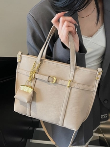 Elegant beige lychee grain leather tote bag with decorative buckle and mini charm