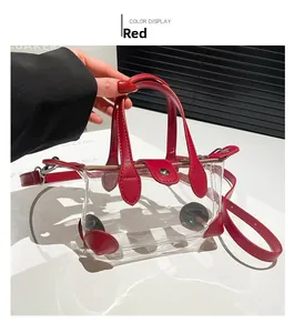 Detailansicht der roten transparenten PVC-Tasche mit Ledergriffen und verstellbarem Gurt