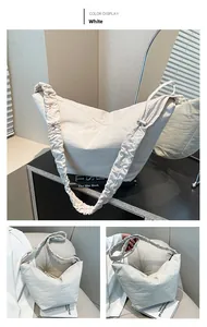 Detailed close-up of a white pleated dumpling bag featuring a ruffled shoulder strap