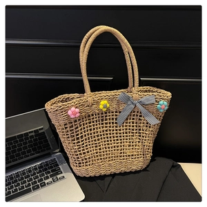 Detail showing artisanal handwoven straw mesh and colorful 3D floral accents with a bow