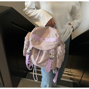 Detail of light purple nylon backpack showing silver metal buckle and drawstring closure