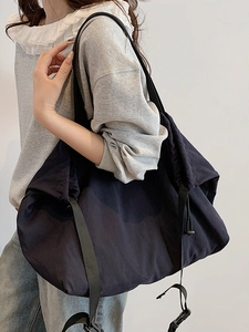 Bolso hobo minimalista grande en nailon azul marino con cierre de cordón y detalle de hebilla