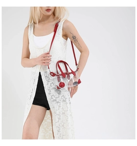 Detailansicht der transparenten PVC-Tasche mit leuchtend rotem Lederbesatz und Griff