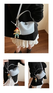 Detail view of light blue saddle bag featuring a pearl strap and cute cartoon pendant accessory