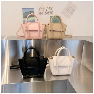 Quatre coloris de sacs seaux en similicuir présentés sur un présentoir métallique