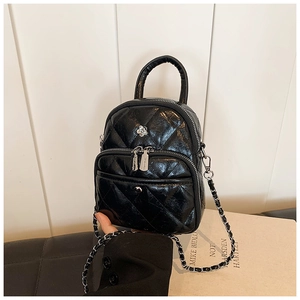 Détail du mini sac à dos noir matelassé avec bandoulière chaîne et logo en fleur